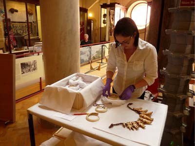 Heather Donoghue packing objects from the de-installed Baron von Hugel case at MAA